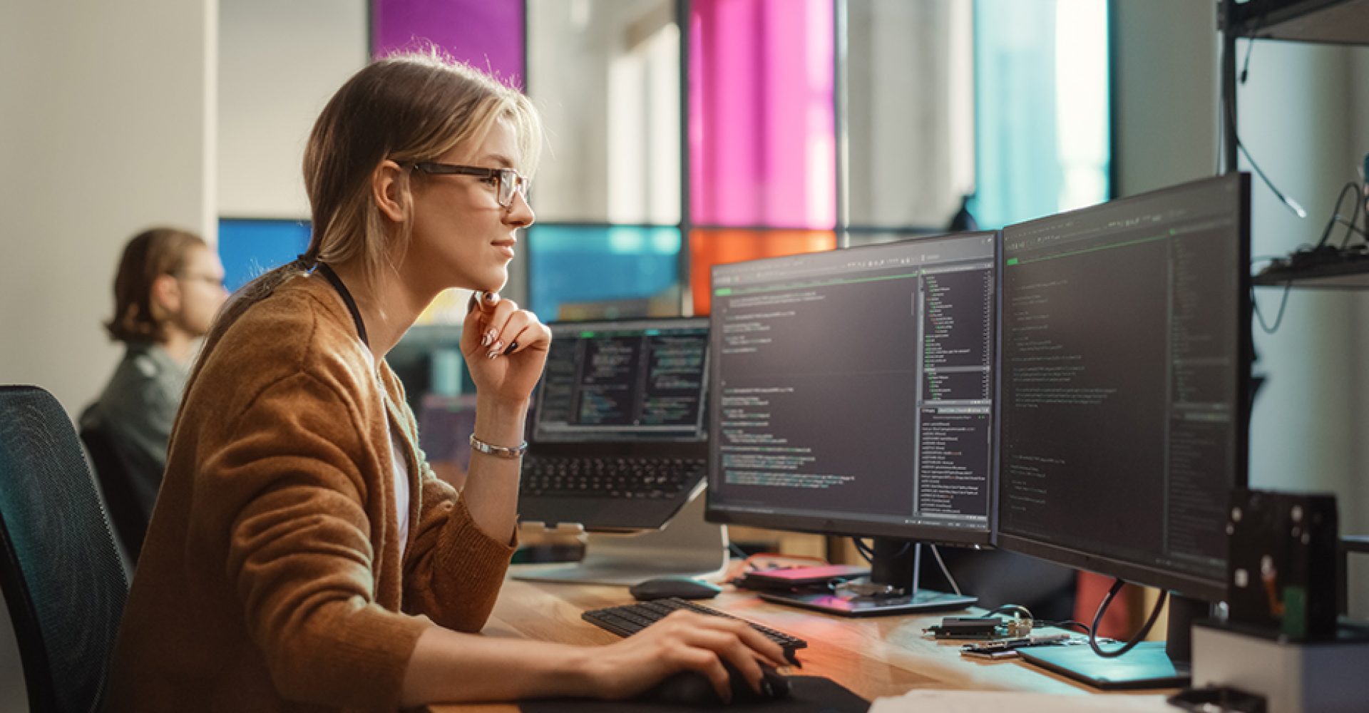 Female Software Engineer Writing Code on Desktop Computer with M
