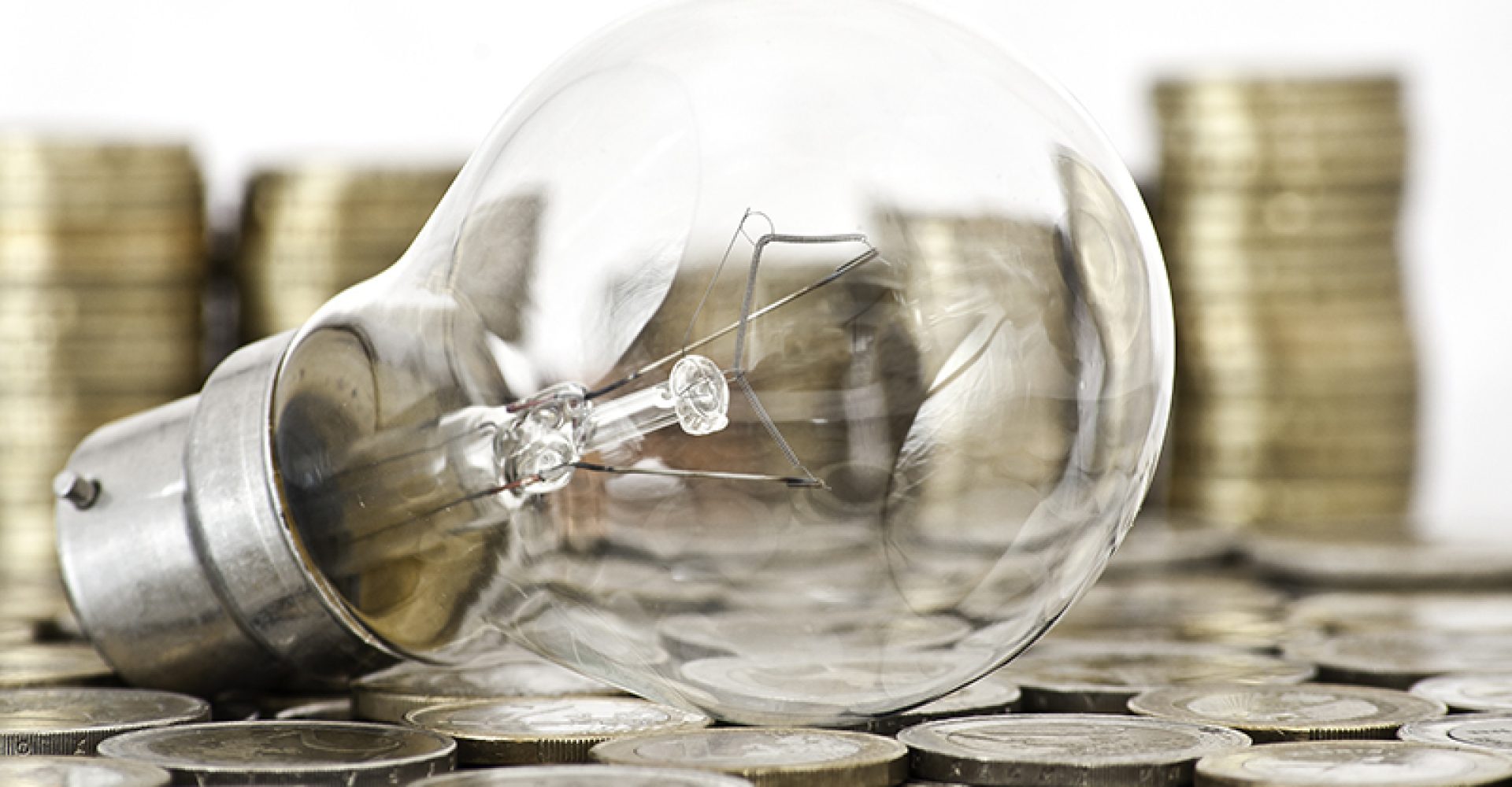 filament bulb lying on euro coins