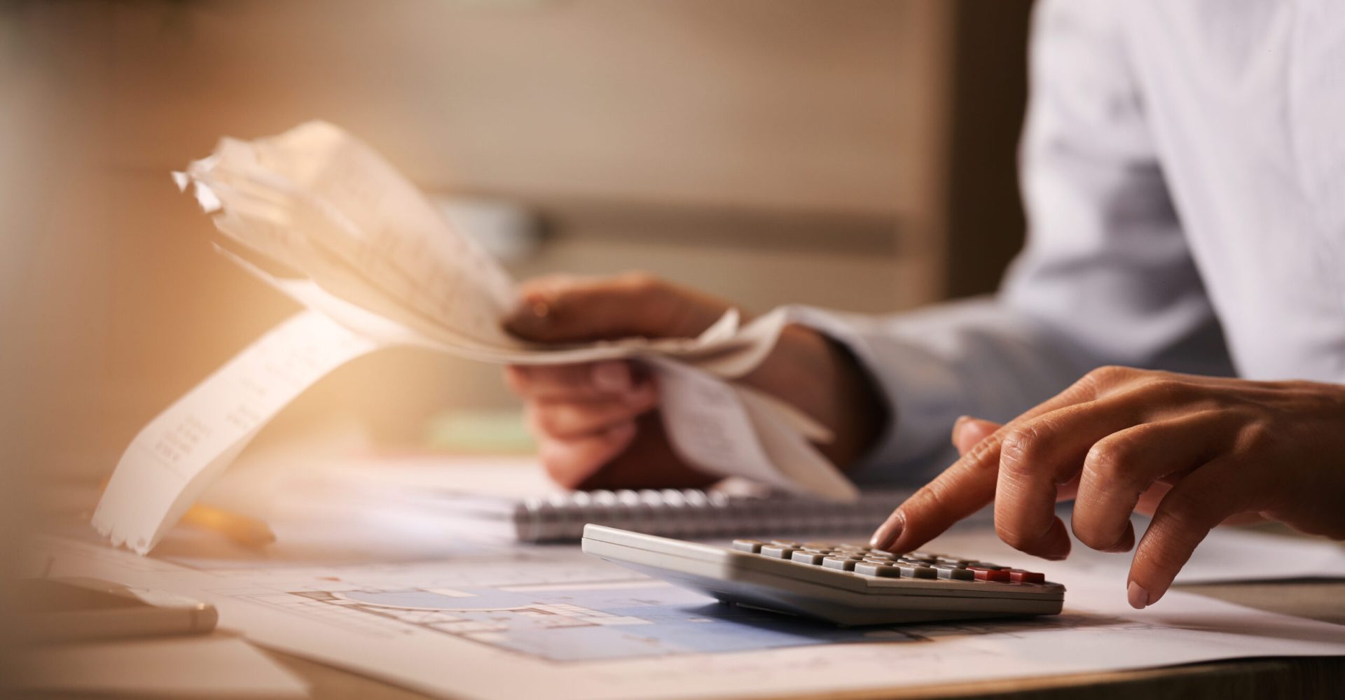Close-up of business accountant using calculator while working i