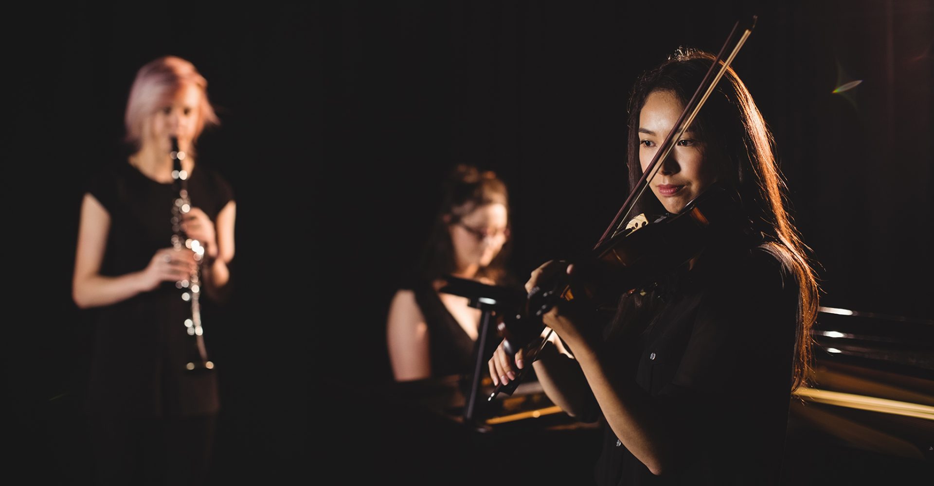 Women playing various instrument in music school