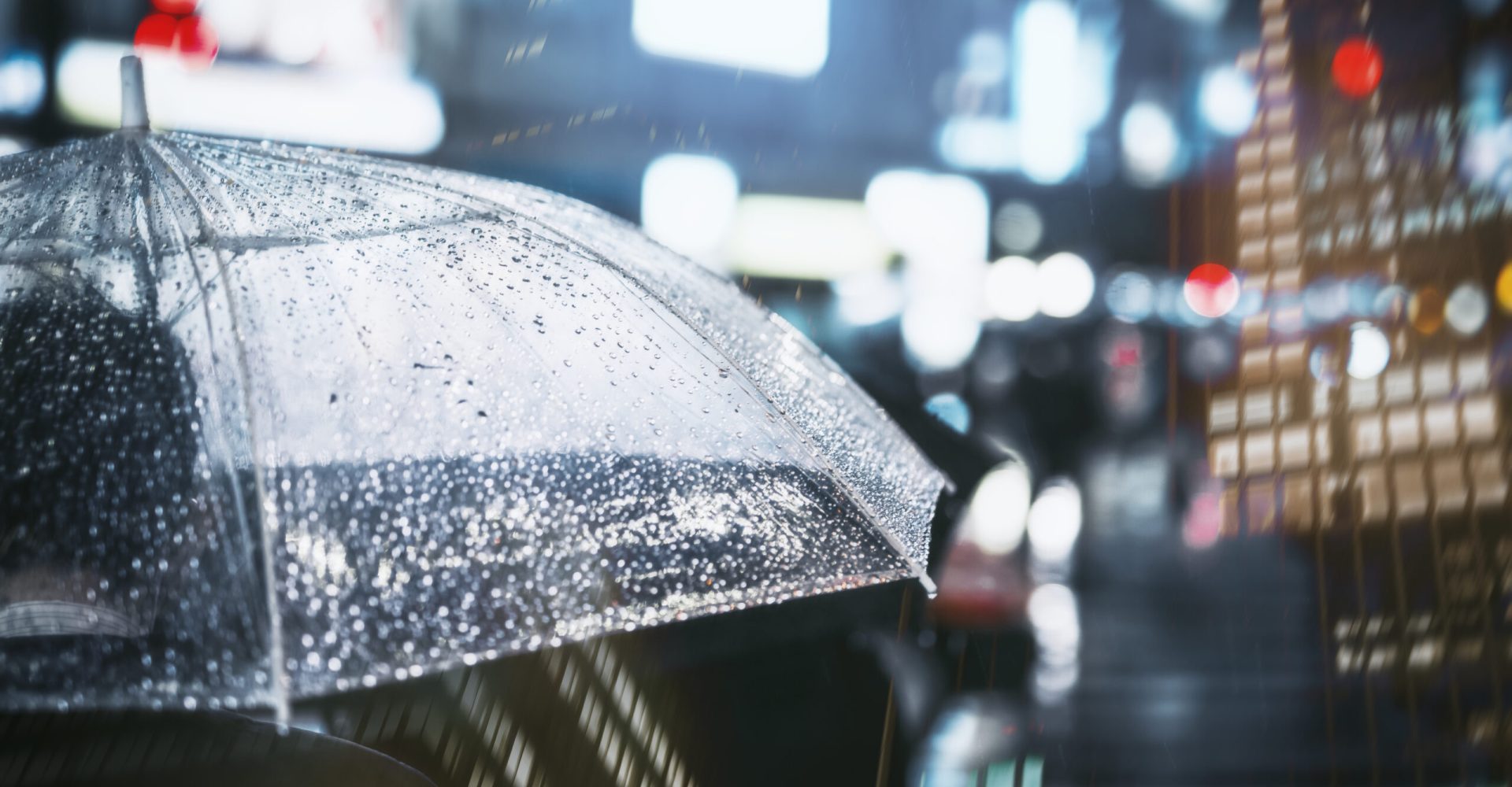 Businessman with umbrella in rainy city