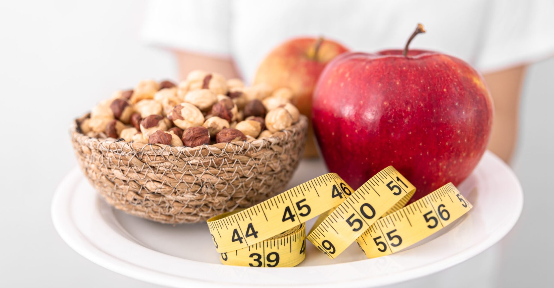 Close up of a plate of apples and hazelnuts on a blurred background, the concept of losing weight, healthy eating.